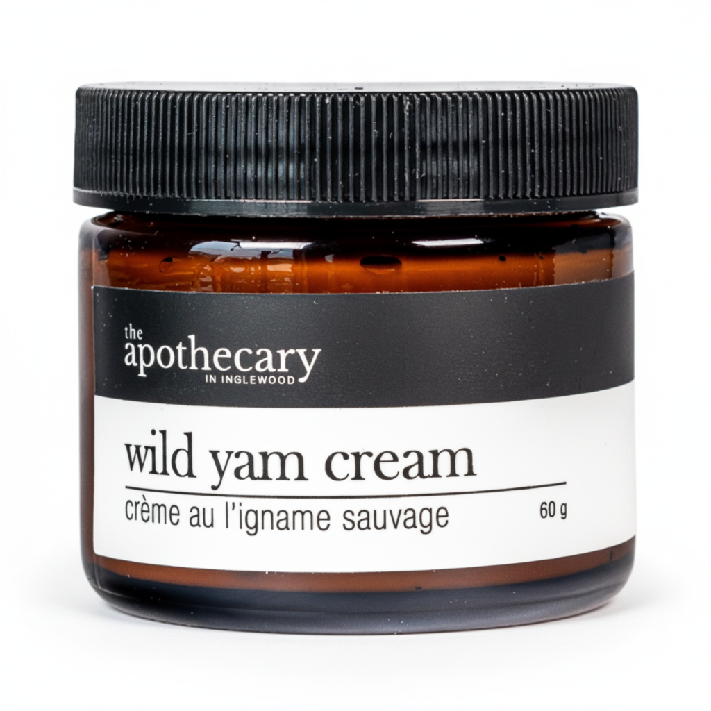 An amber glass jar of 'the apothecary' Wild Yam Cream with a black ribbed screw cap and a black and white label.