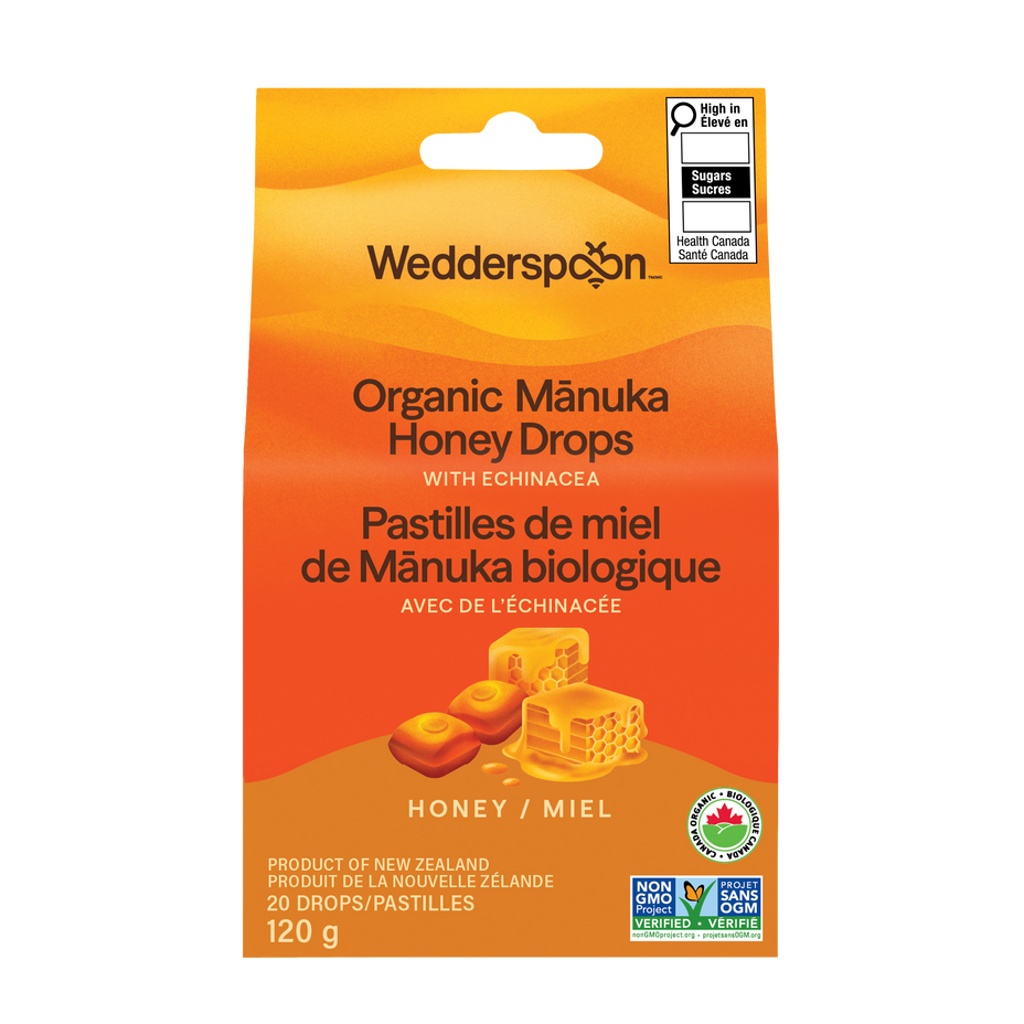 Wedderspoon Organic Mânuka Honey Drops in a yellow-orange hanging pouch with bilingual text and product imagery, shown on a plain white background.